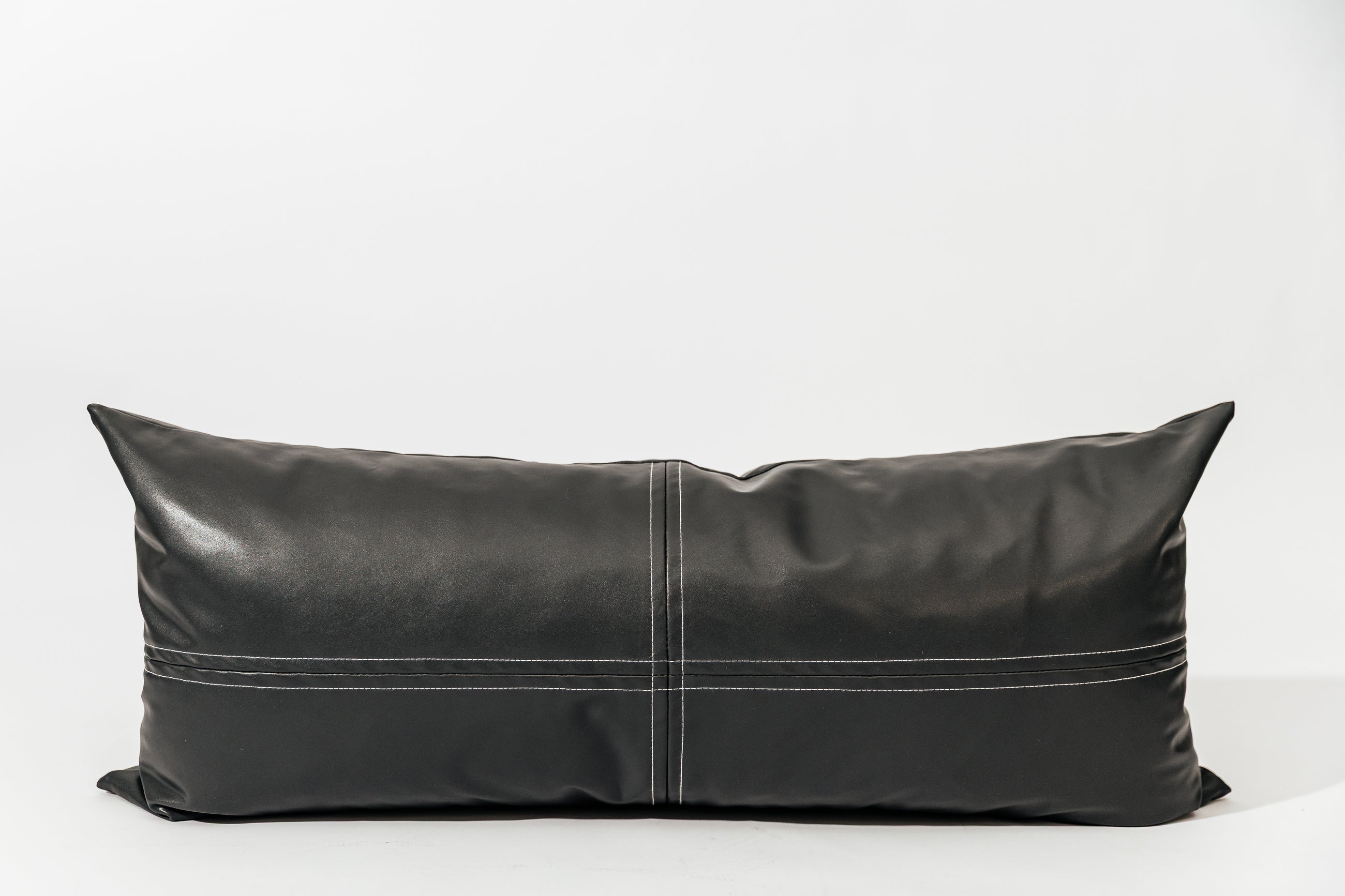 A charcoal lumbar pillow on a white backdrop.
