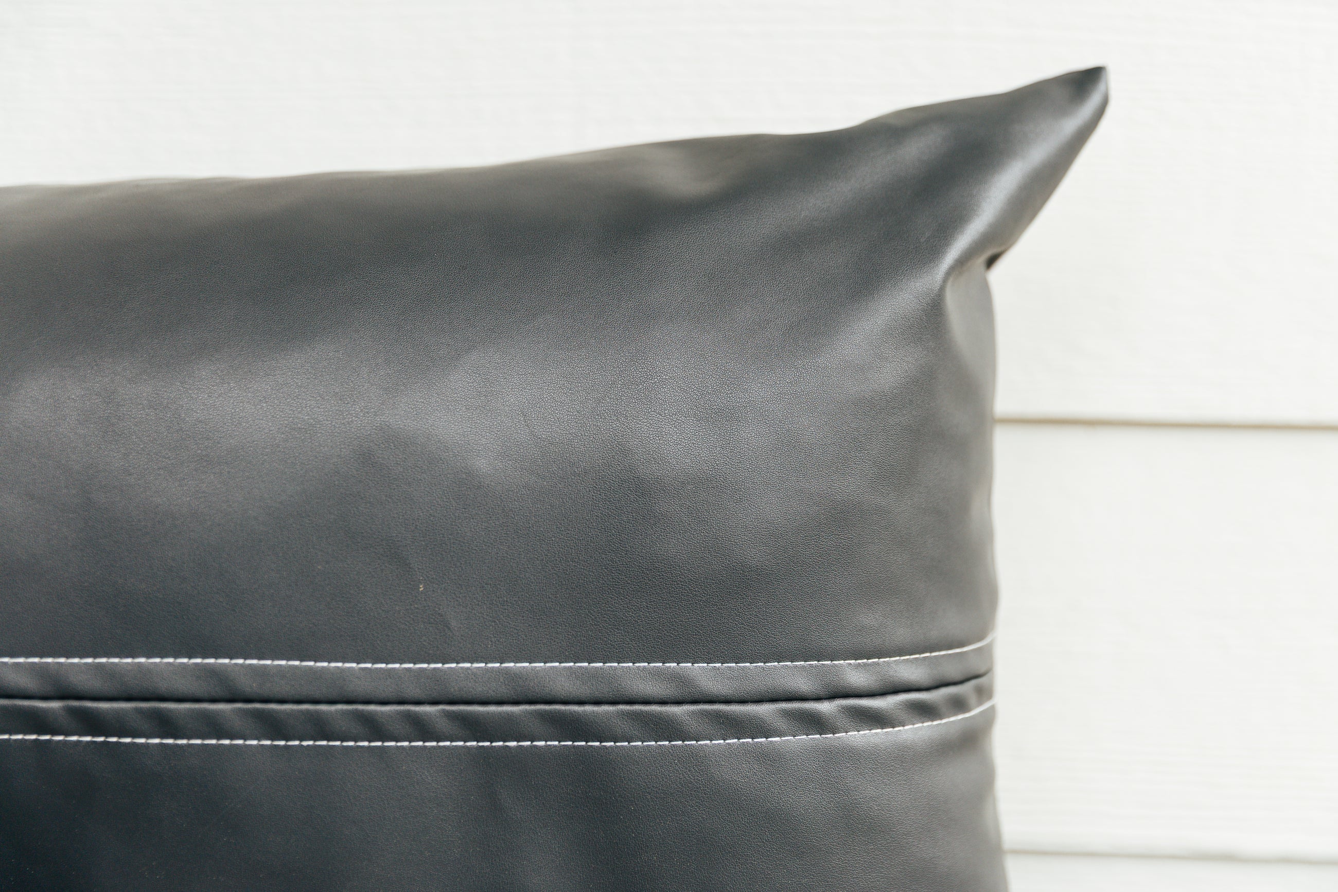A close up on the exterior look and detailing of a charcoal lumbar pillow.