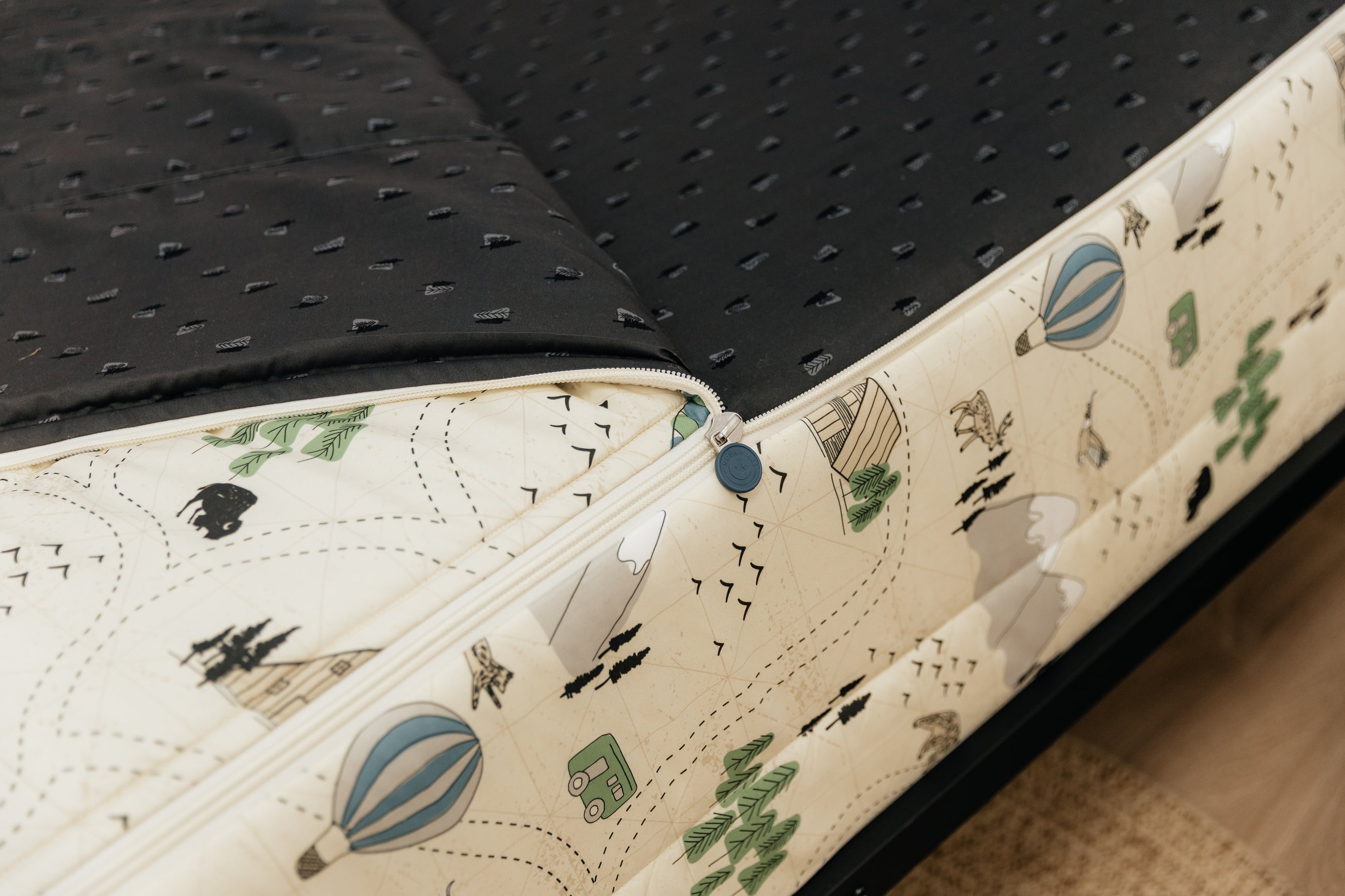 a tight shot of the zipper feature on a set of outdoor-themed zipper bedding.