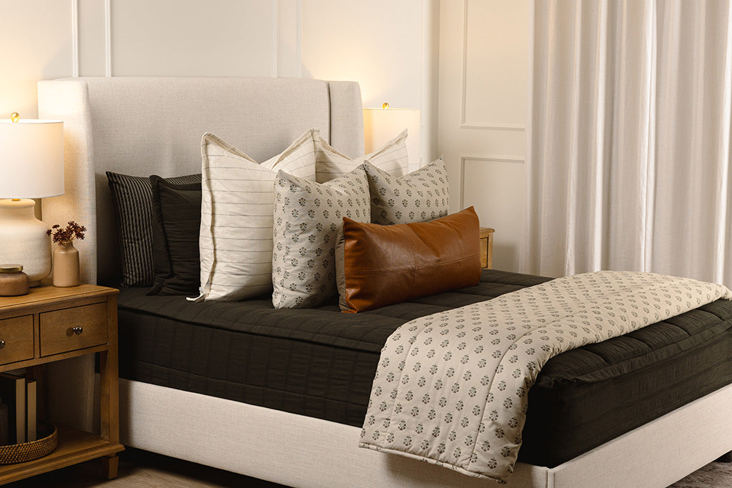 Knit, black zipper bedding with white, floral, and leather accessories. 