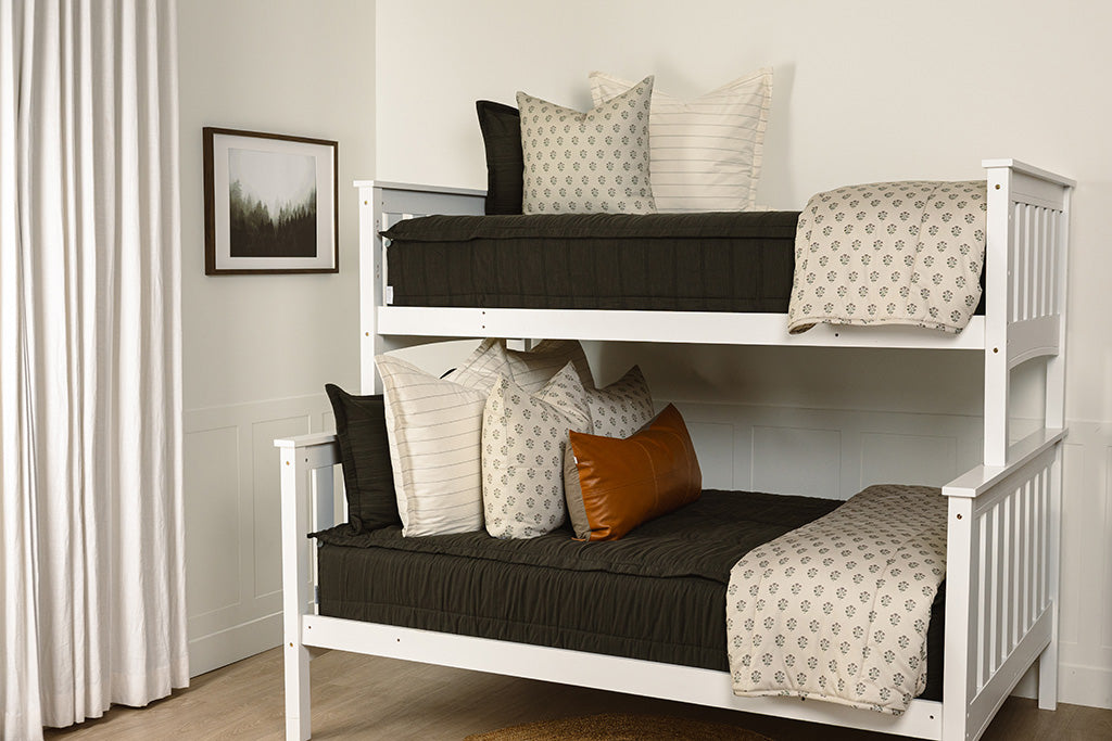 Black knit zipper bedding with white, floral, and leather accessories.