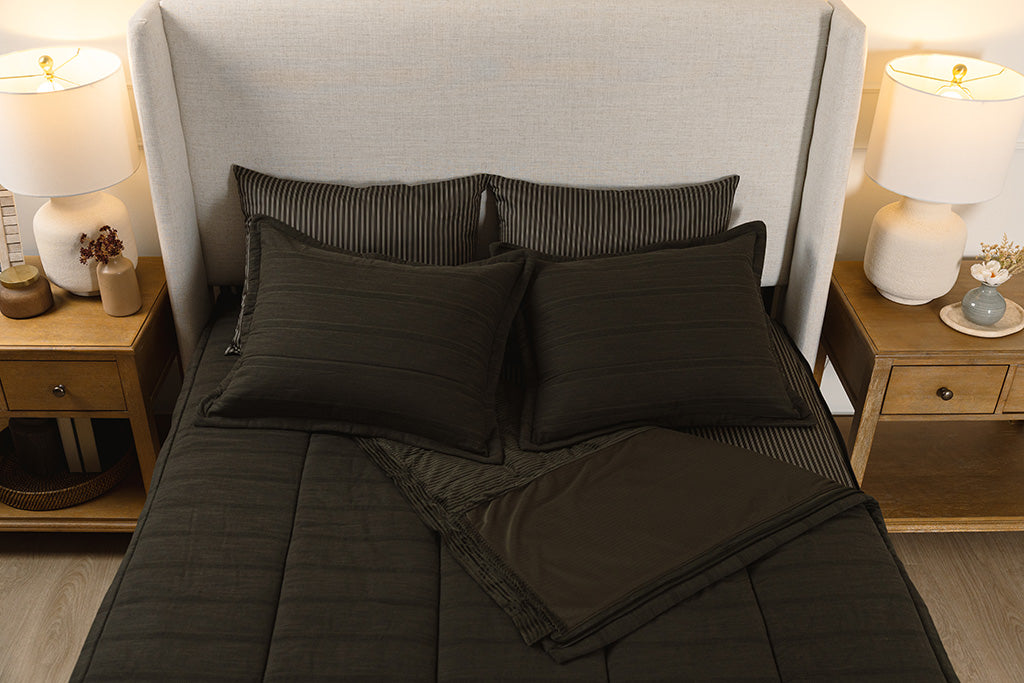 Overhead photo of black knited zipper bedding with black and tan striped bed sheets and black corduroy minky interior.