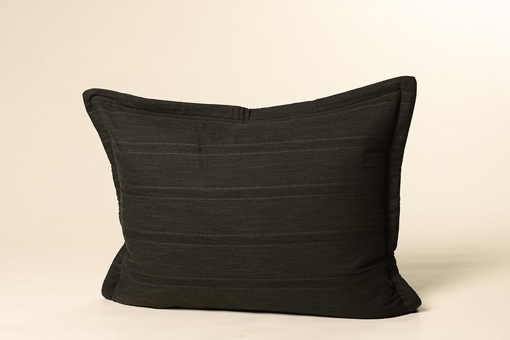 A black knit sham on a cream backdrop.