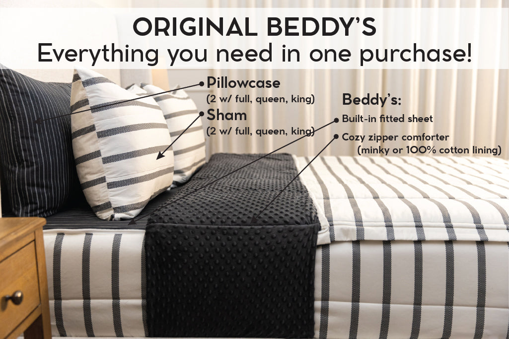 A bed made with white and black striped zipper bedding with the top unzipped and pulled back to show the inside lining