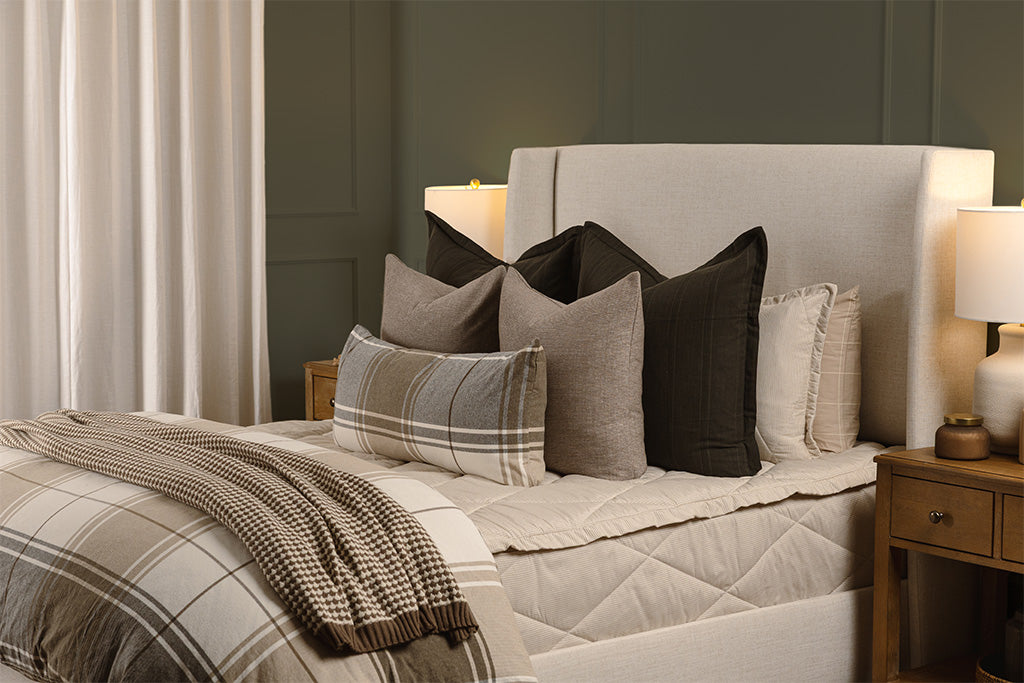 Striped, quilted, tan zipper bedding with black, brown, plaid, and knit accessories.