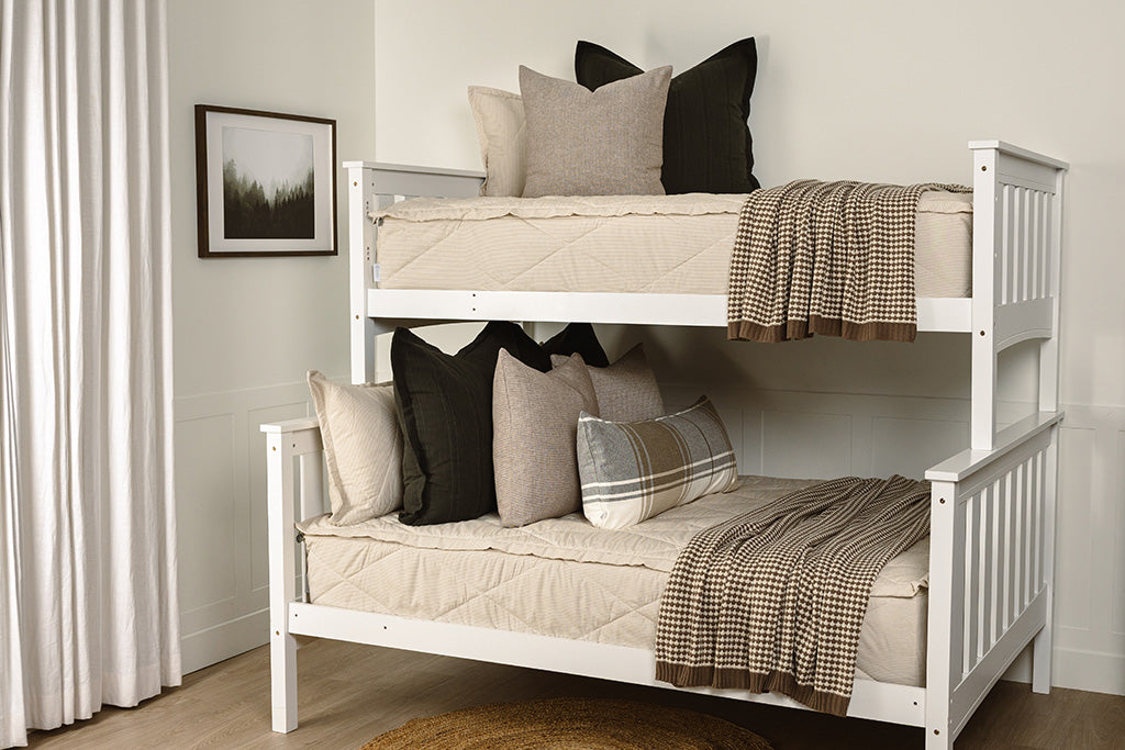 Tan stripe quilted zipper bedding with black, brown, plaid, and knit accessories.