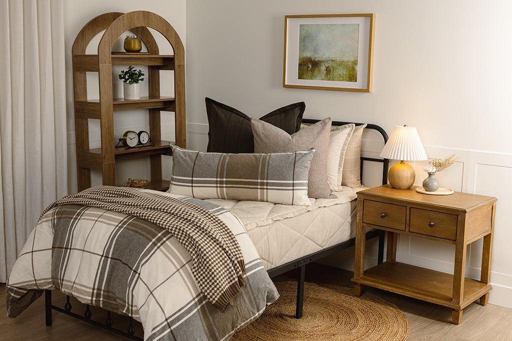 Striped, quilted, tan zipper bedding with black, brown, plaid, and knitted accessories. 