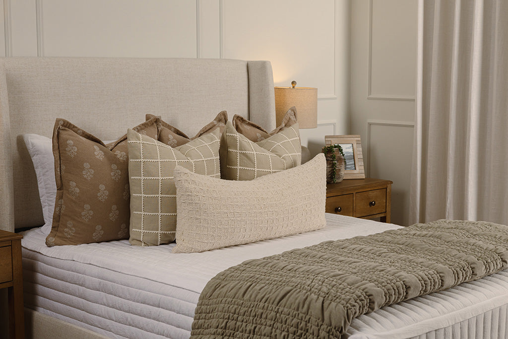 White stripe quilt zipper bedding with tan, cream, and green accessories.