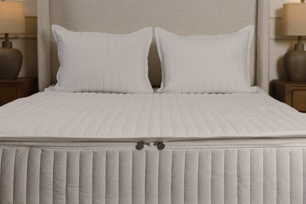 End of bed showing double zippers on white stripe quilt zipper bedding.