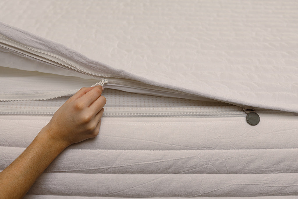 Close up of zipping layers in white stripe quilt zipper bedding.