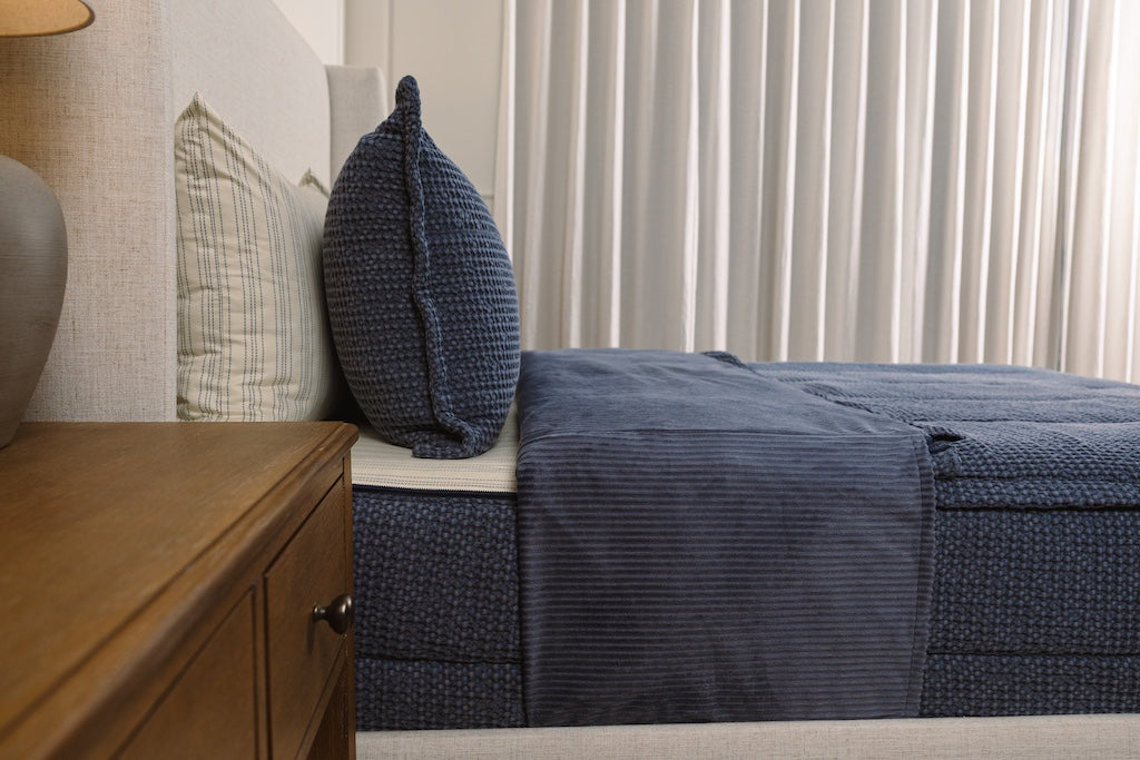 Side view of dusted blue knitted zipper bedding.