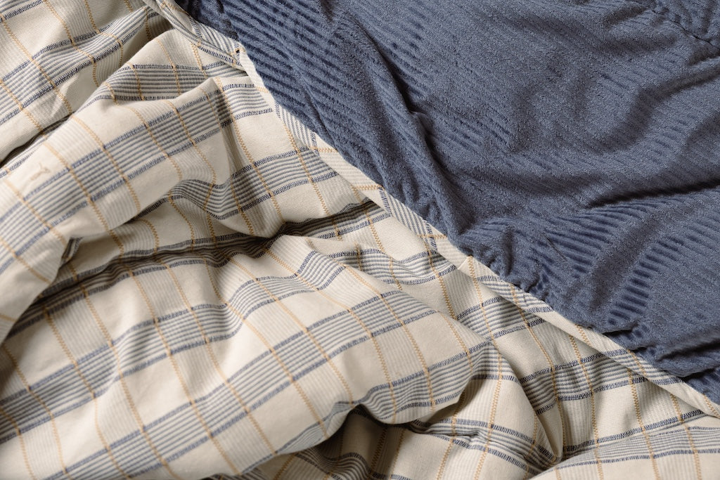 Photo that shows both blue corduroy minky and blue, cream, and yellow plaid blanket.