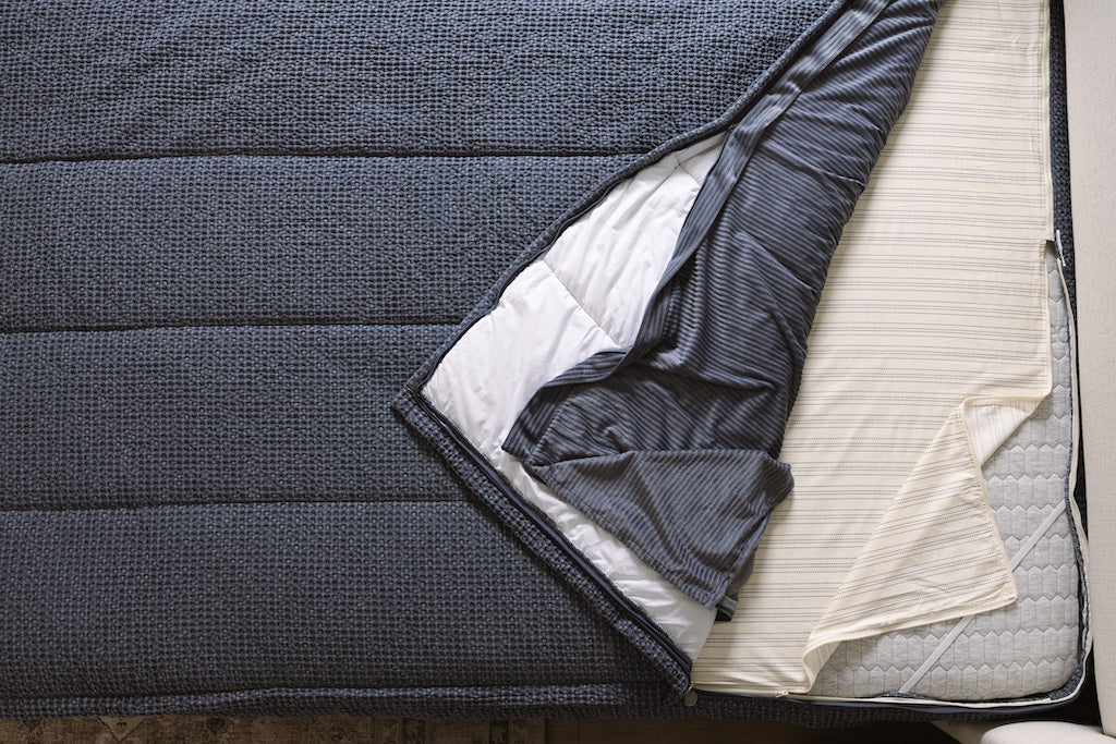 Overhead shot of blue waffle texture zipper bedding layers.