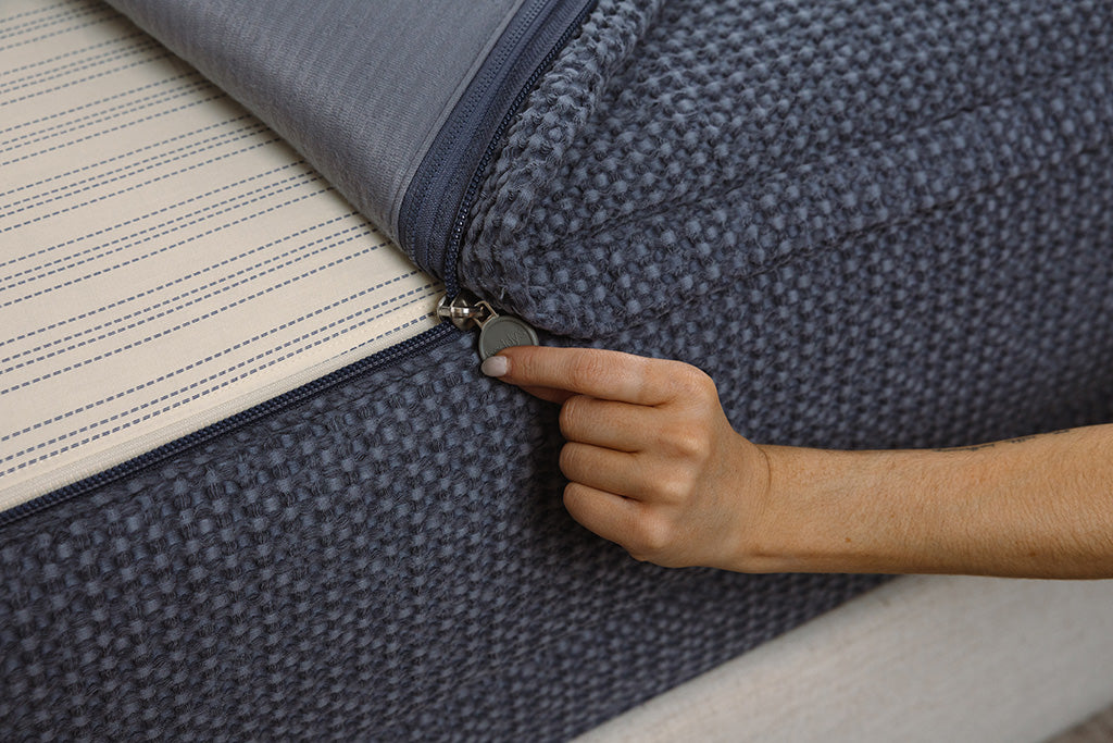 Close up photo of zipper being pulled on blue waffle texture zipper bedding.