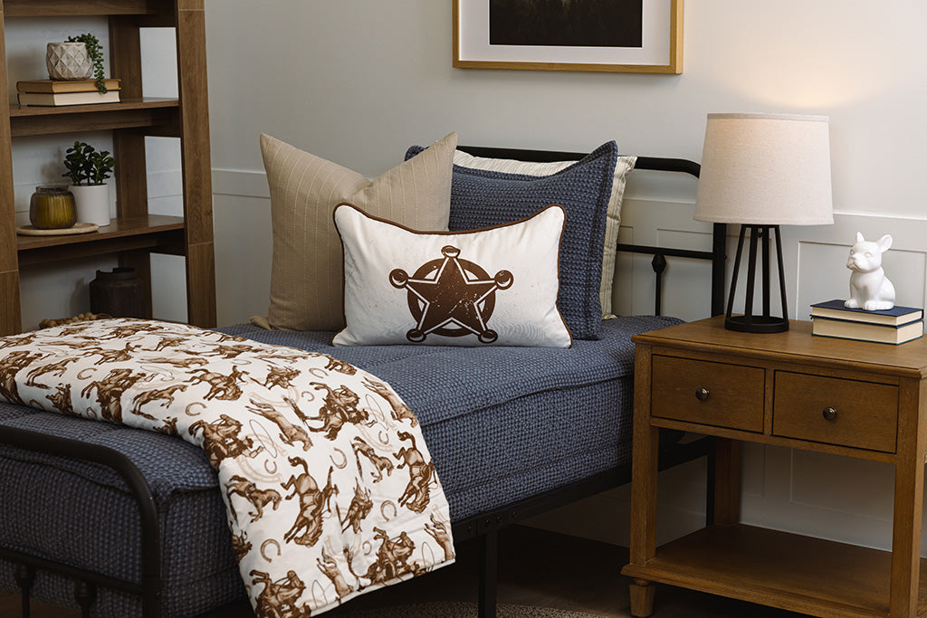 Twin bed with blue waffle texture zipper bedding with western accessories.