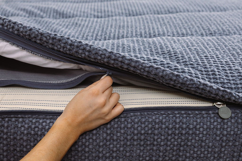 Close up of zipping layers in blue waffle texture zipper bedding.