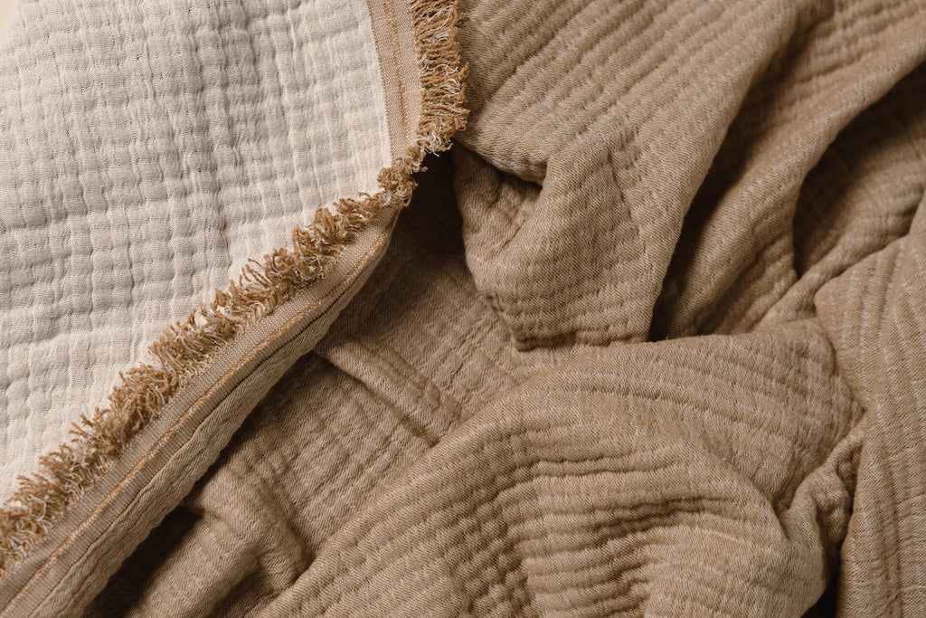 Photo that shows both light brown and cream sides of throw blanket.