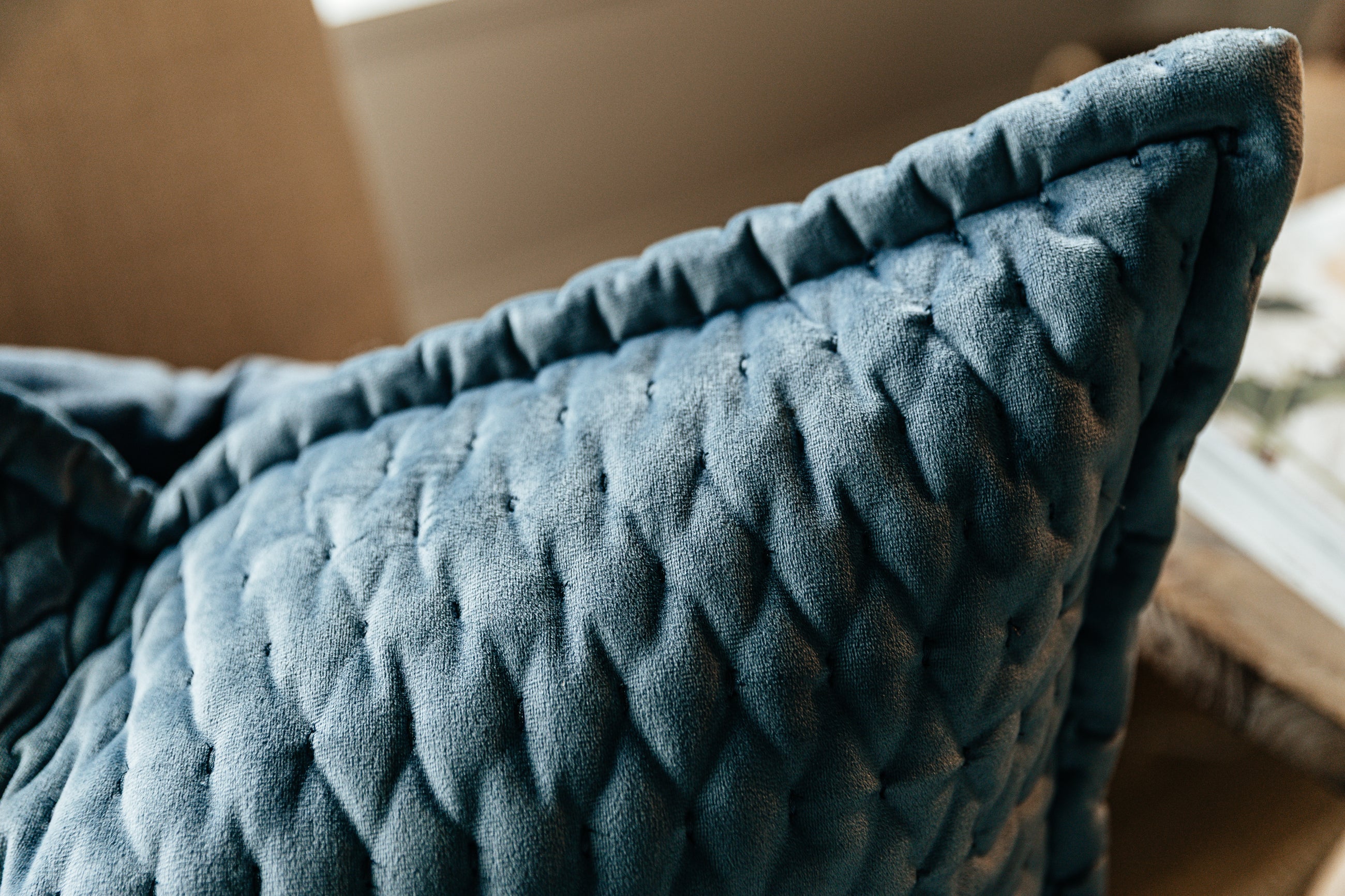 A close up corner view of a blue velvet euro pillow.