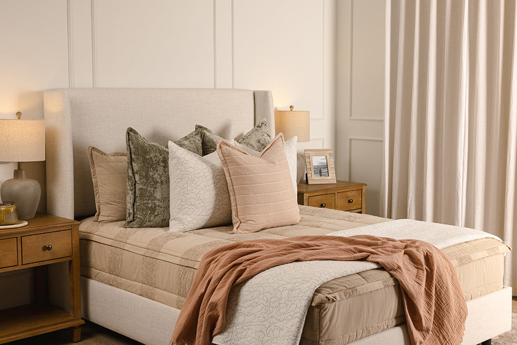 Tan neutral zipper bedding with green, pink, and white accessories. 