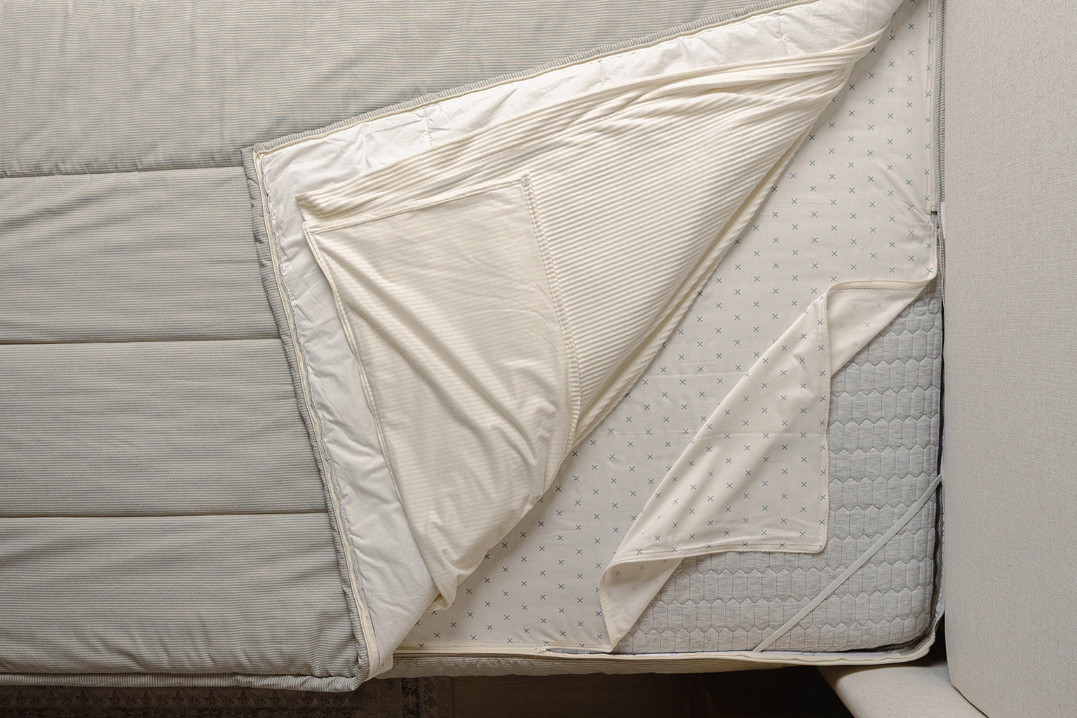 Overhead shot of blue and white stripe zipper bedding layers.