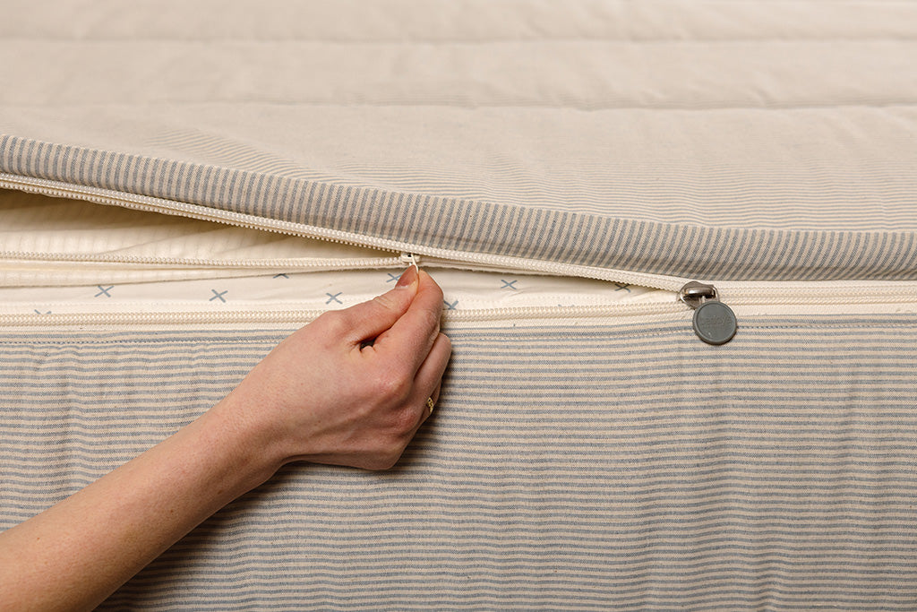 Close up of zipping layers in blue stripe zipper bedding.