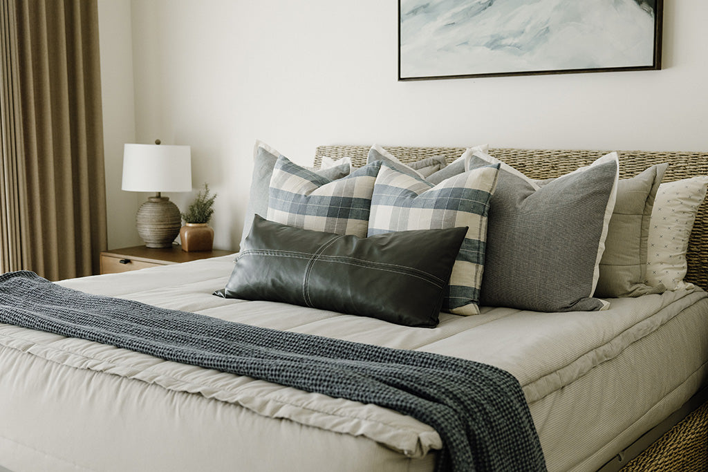 A blue and white stripe zipper bedding with plaid, grey, and blue accessories. 