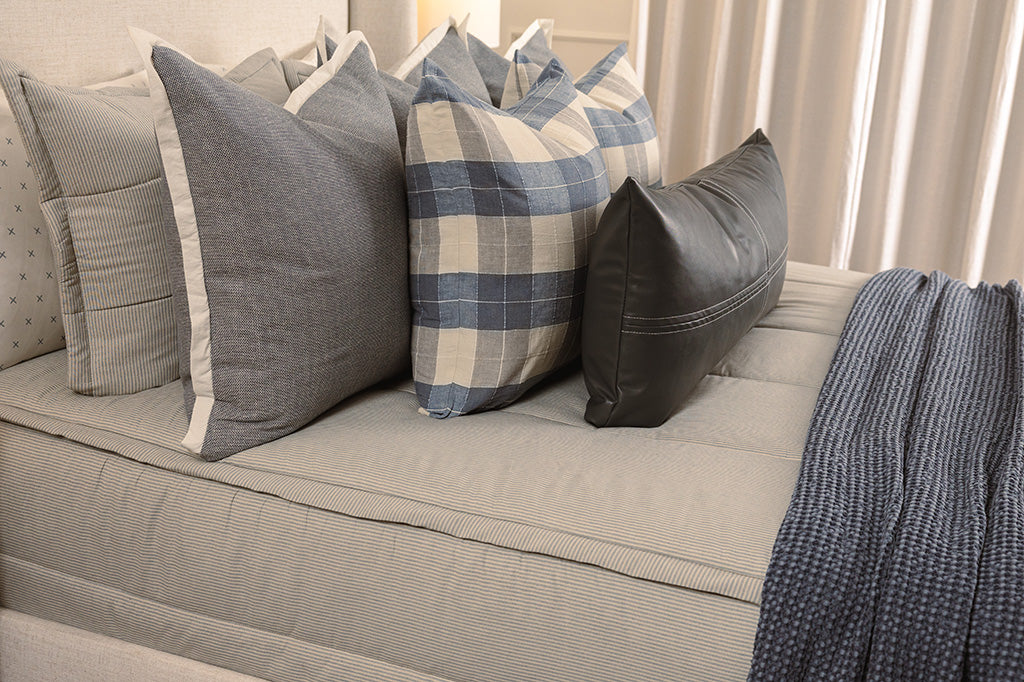 A closeup photo of blue and white striped zipper bedding.