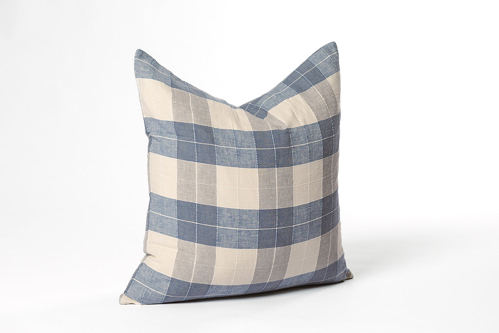 Blue and white plaid pillow on a white backdrop.