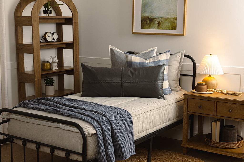 Twin bed with blue and white stripe zipper bedding with plaid, blue and grey accessories.