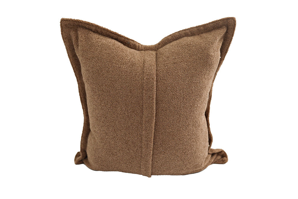 A brown plush suede pillow on a white background.
