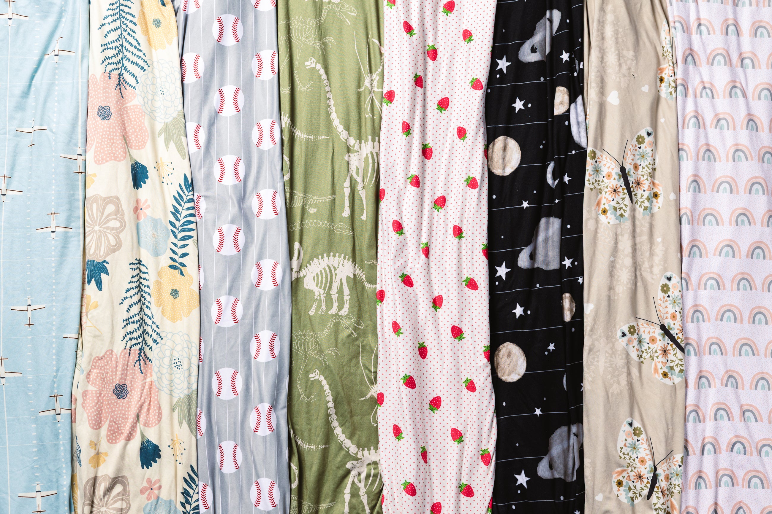 A flat lay of different colored children's travel blankets. 