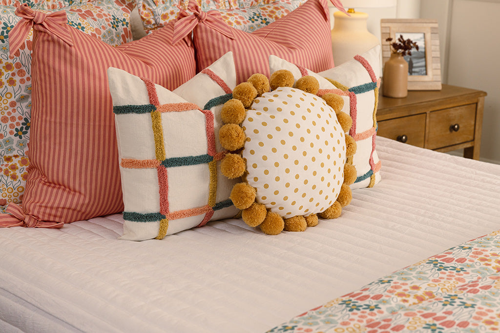 White quilted zipper bedding with multi-color and floral accessories.