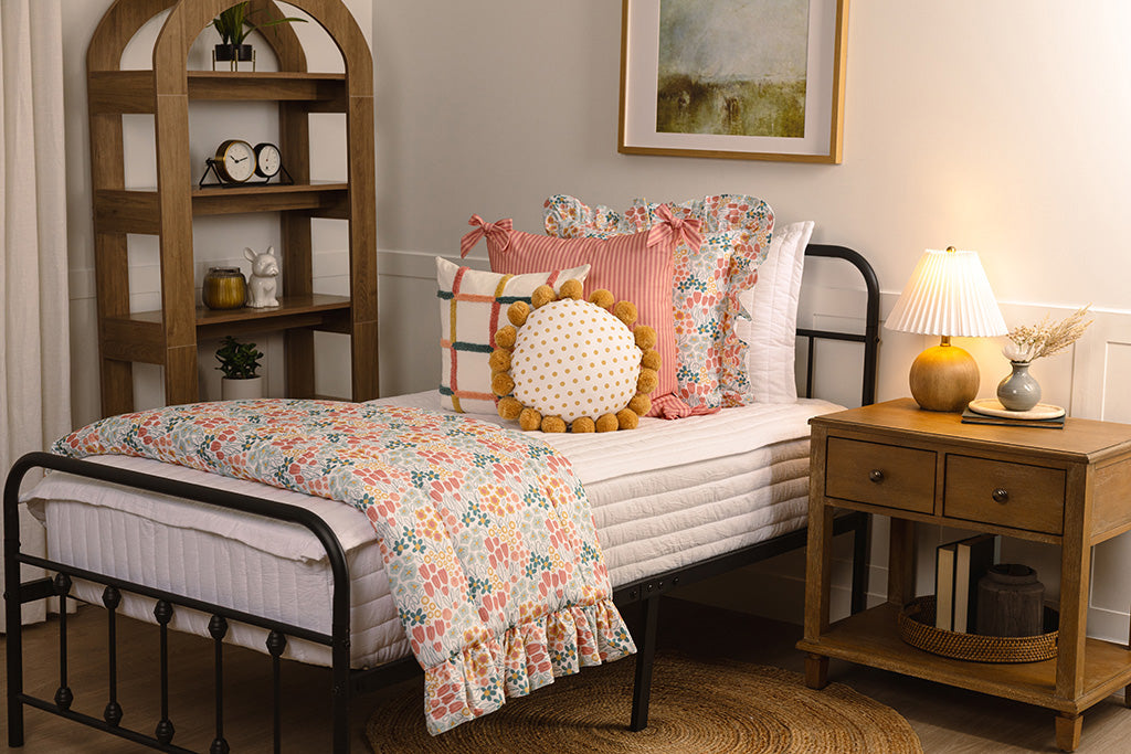 White quilted zipper bedding with multi-color and floral accessories on a twin bed.