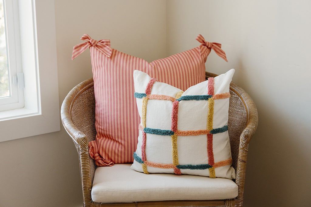 Multi-color pillows on a tan chair.