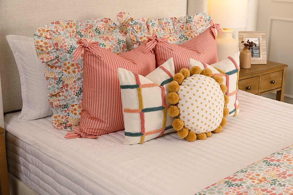 White quilted zipper bedding with multi-color and floral accessories.