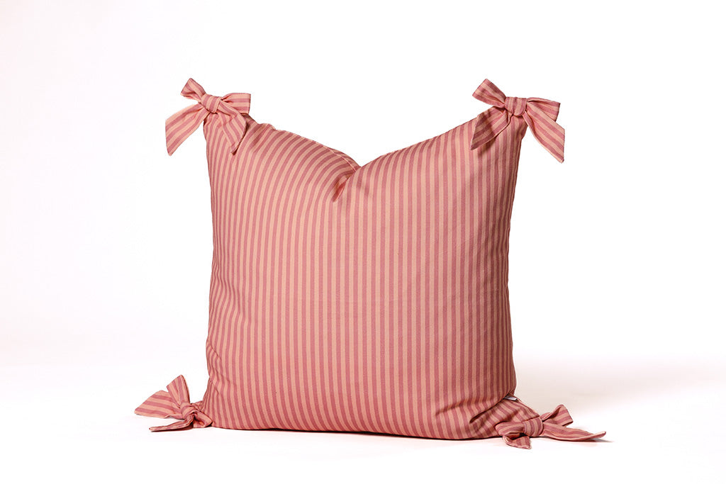 A soft pink on pink stripe pattern pillow on a white backdrop.