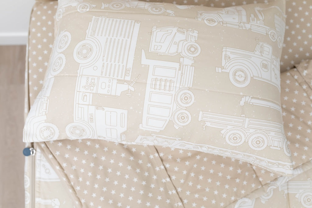 A twin bed made with light tan cars kids zipper bedding, the top unzipped and slightly pulled back and a pillow on the bed.