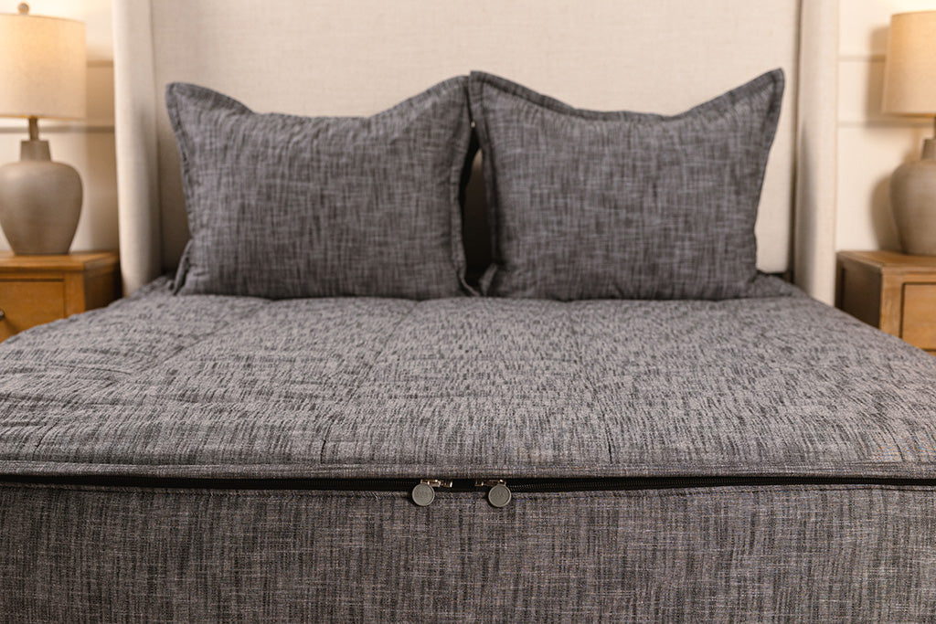 End of bed showing double zippers on gray zipper bedding.