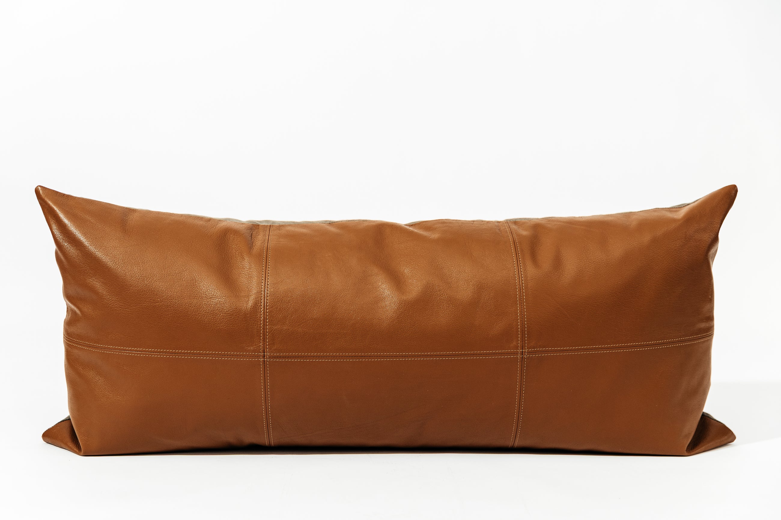 A neutral leather XL lumbar pillow with stitching on a white background.
