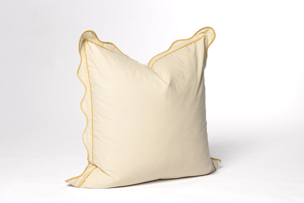 A yellow pillow on a white backdrop.