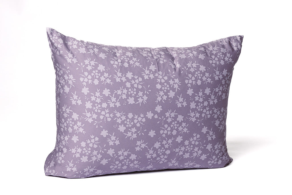 A floral purple pillowcase on a white backdrop.