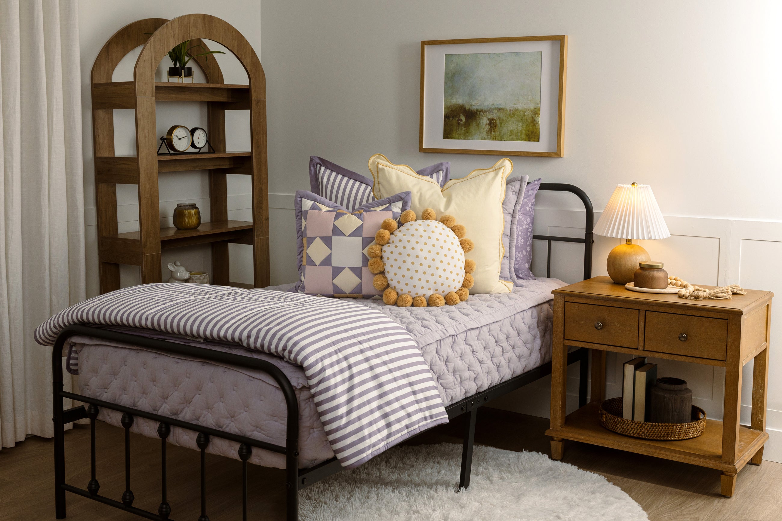 Twin bed with purple knitted zipper bedding with purple, yellow, and white accessories.
