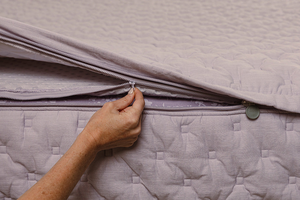 Close up of zipping layers in purple puffed zipper bedding.