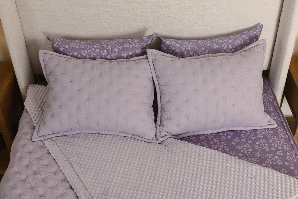 Overhead photo of purple puffed zipper bedding with purple floral bed sheets and purple bubble minky interior.