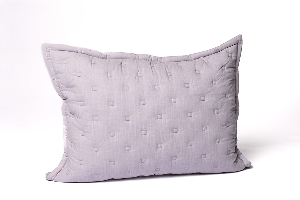 A purple knitted sham on a white backdrop.