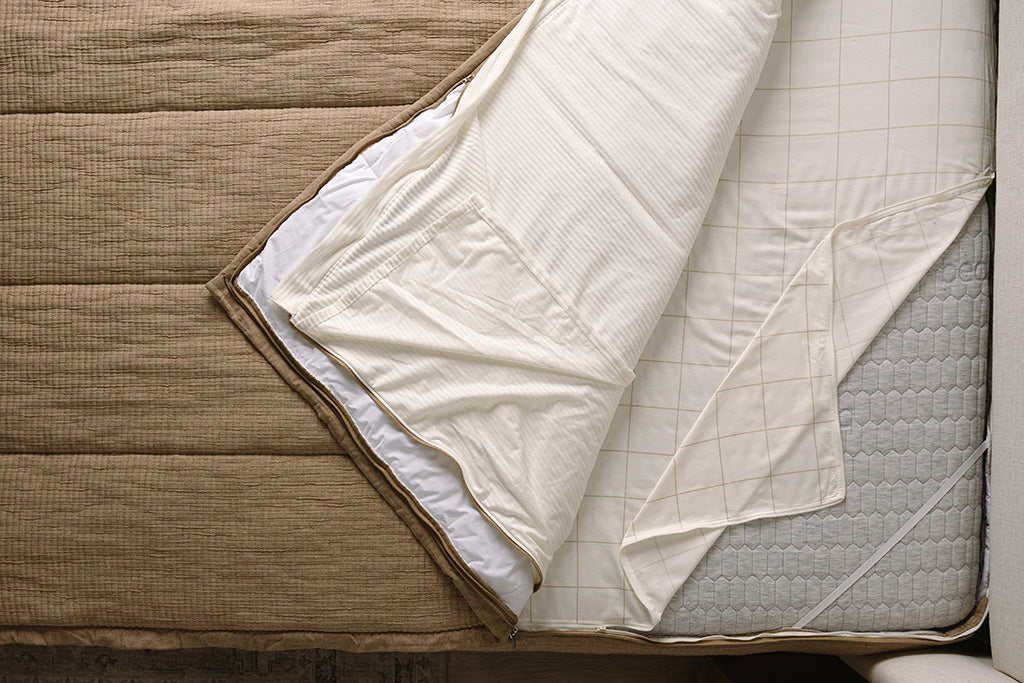 Overhead shot of tan knitted texture zipper bedding layers.