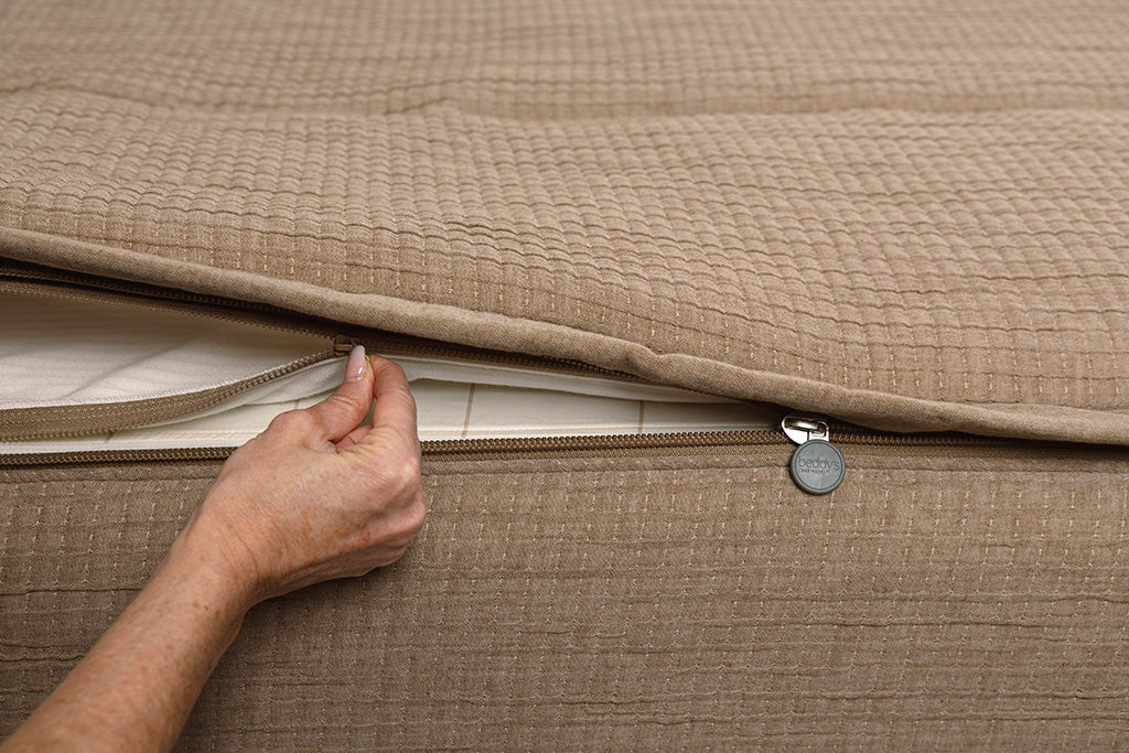 Close up of zipping layers in tan woven zipper bedding.