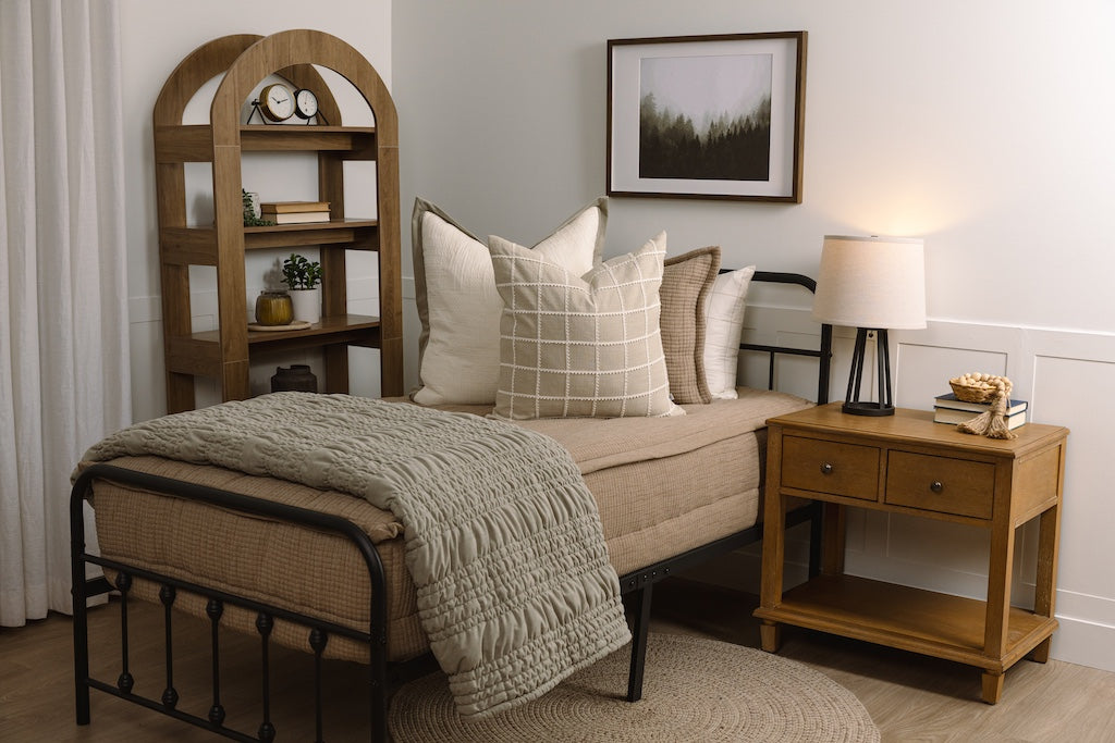Twin bed with tan woven zipper bedding with cream and green accessories.