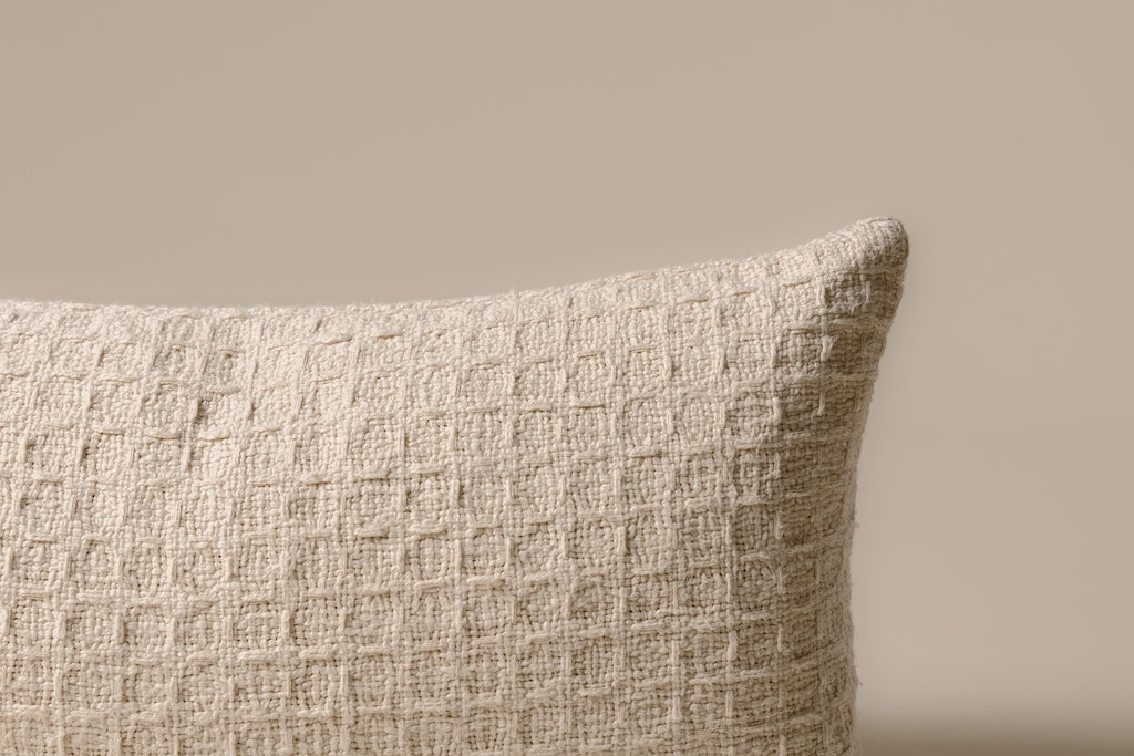 A cream woven XL lumbar pillow on a cream backdrop.