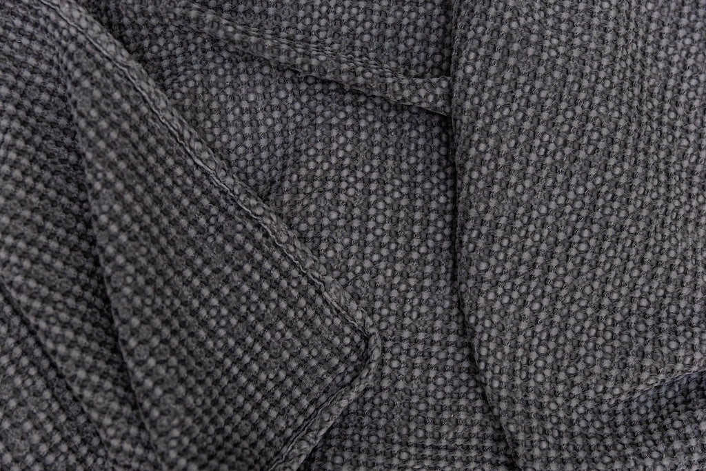 Photo that shows a folded gray textured waffle weave blanket.